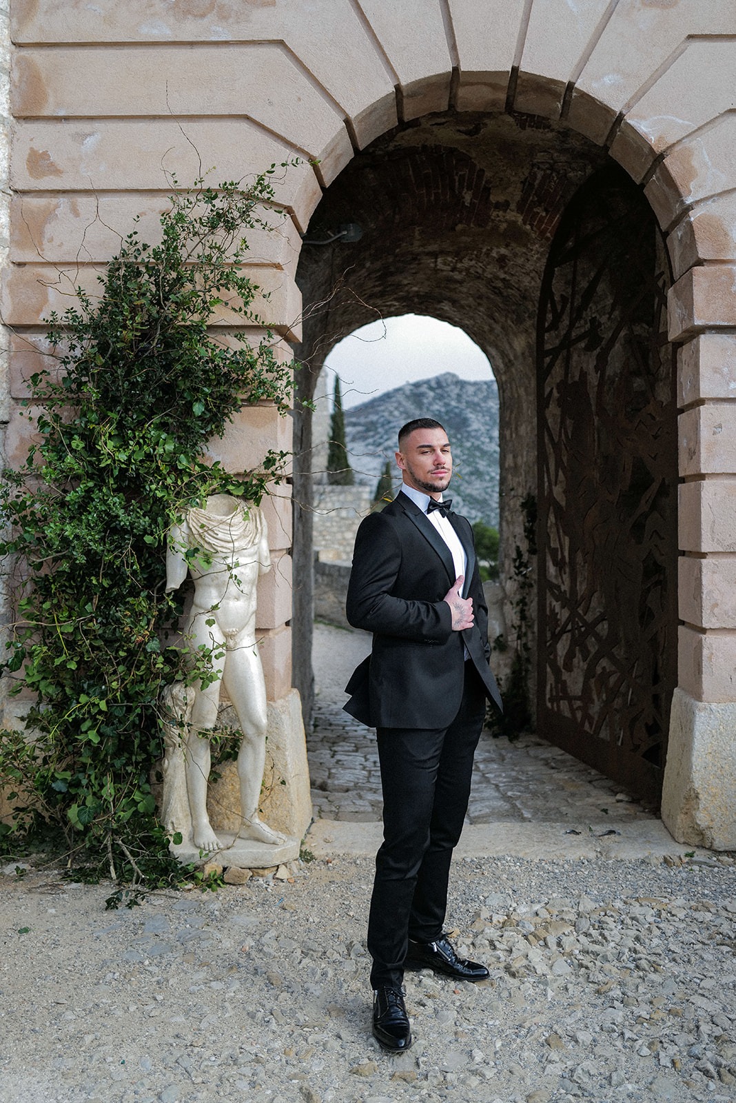 groom in fitted black tuxedo