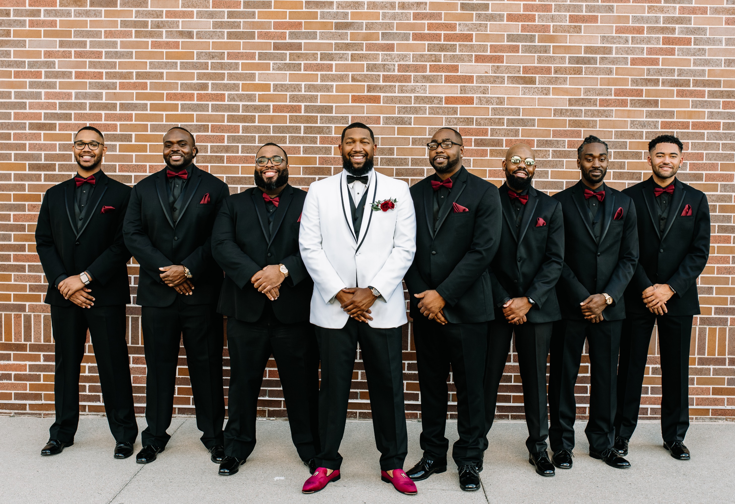 groomsmen in black tuxes with red ties