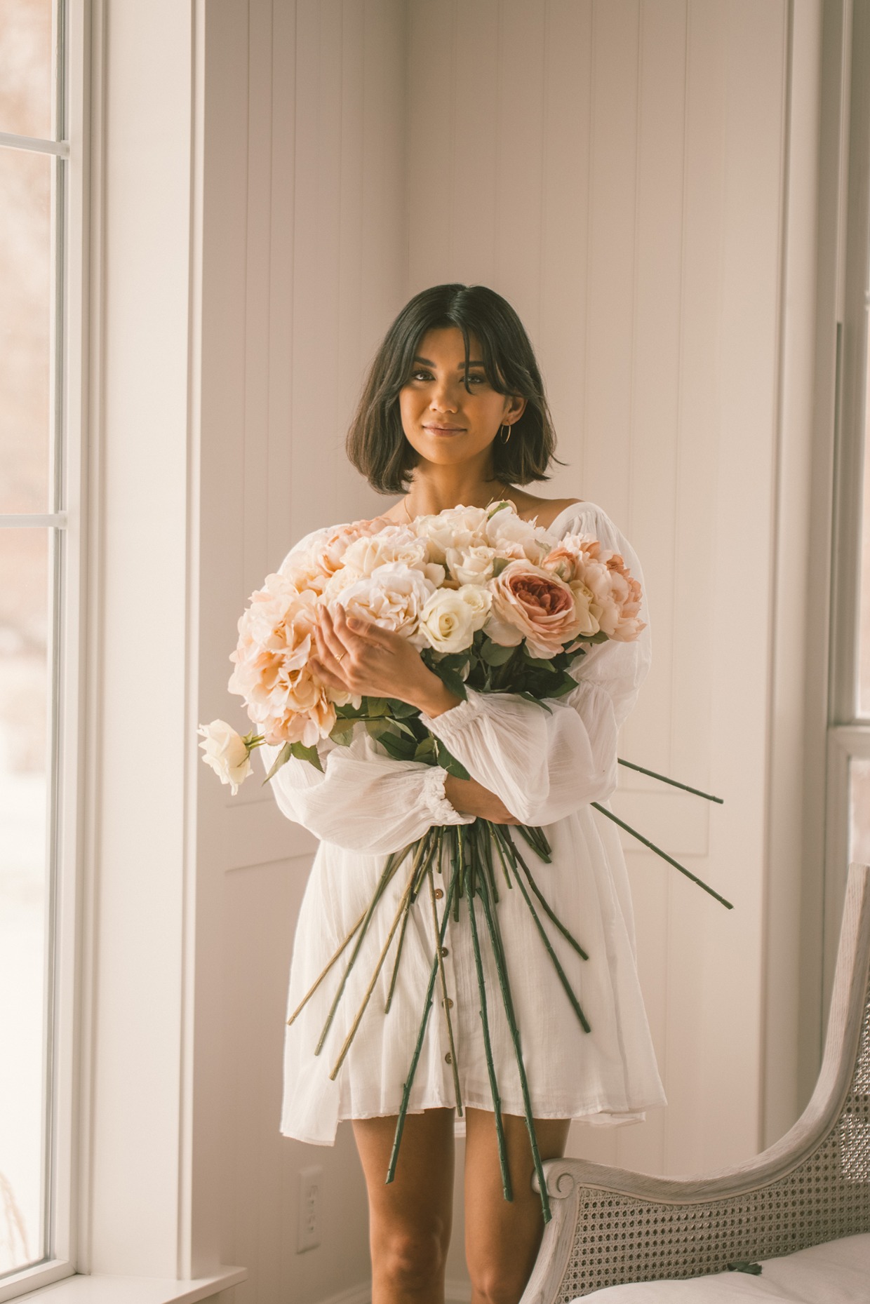 bride holding blush flowers and wearing earrings from Made by Mary