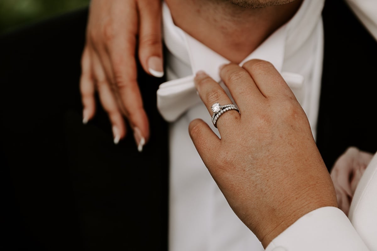 bride adjusts white bowtie