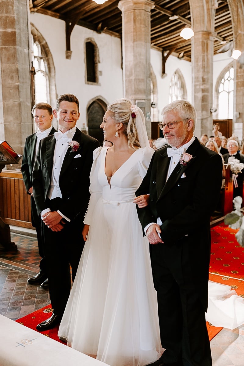 bride and groom stand at altar 