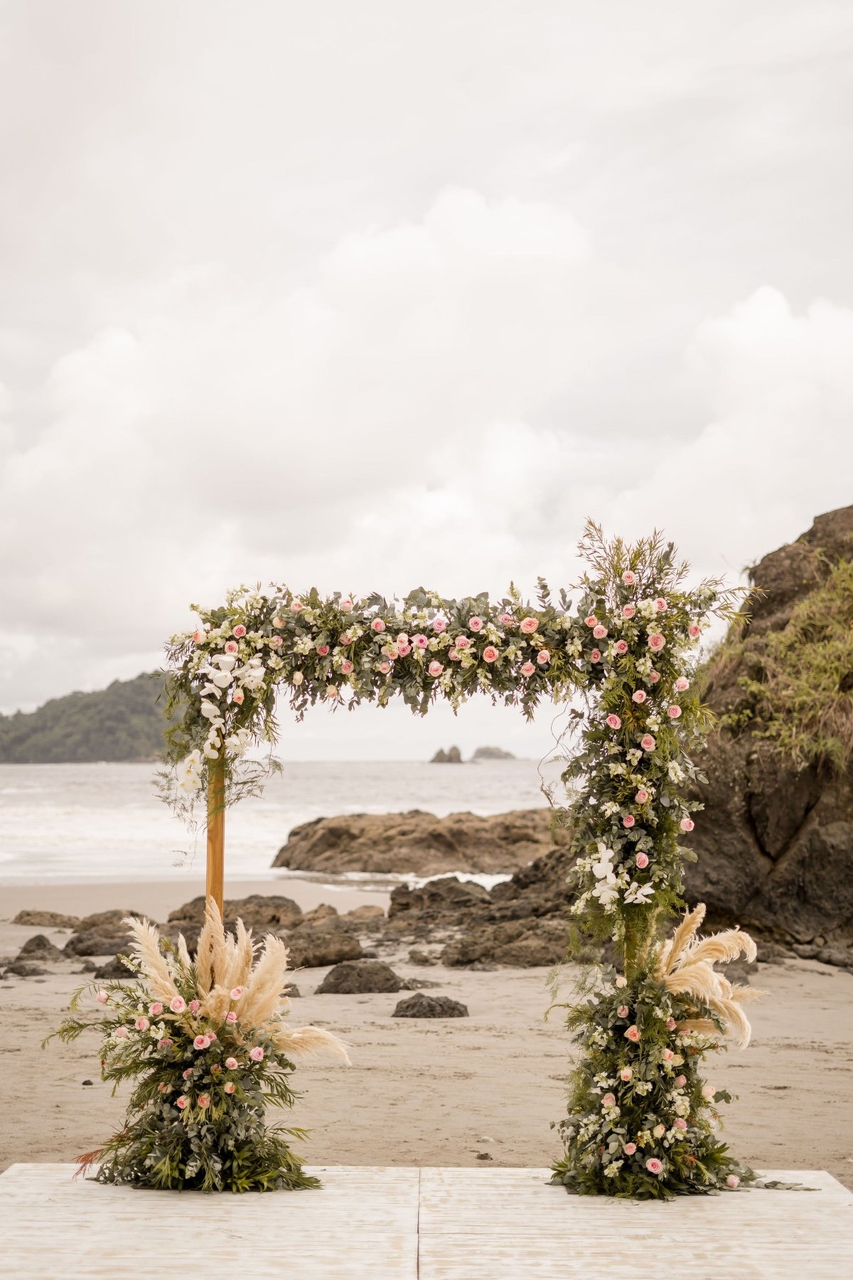 pink floral arch for beach wedding