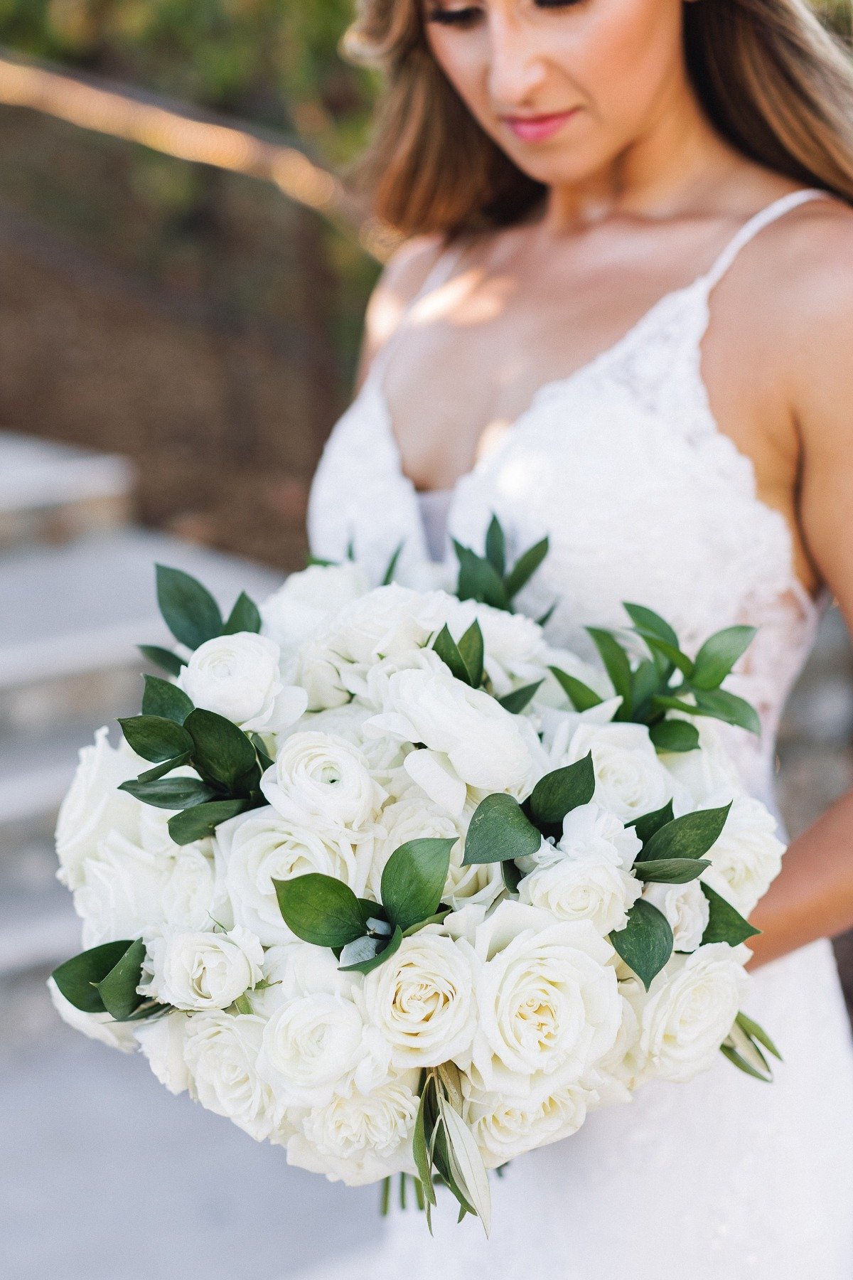 spaghetti strapped v neck lace wedding gown and white rose bouquet