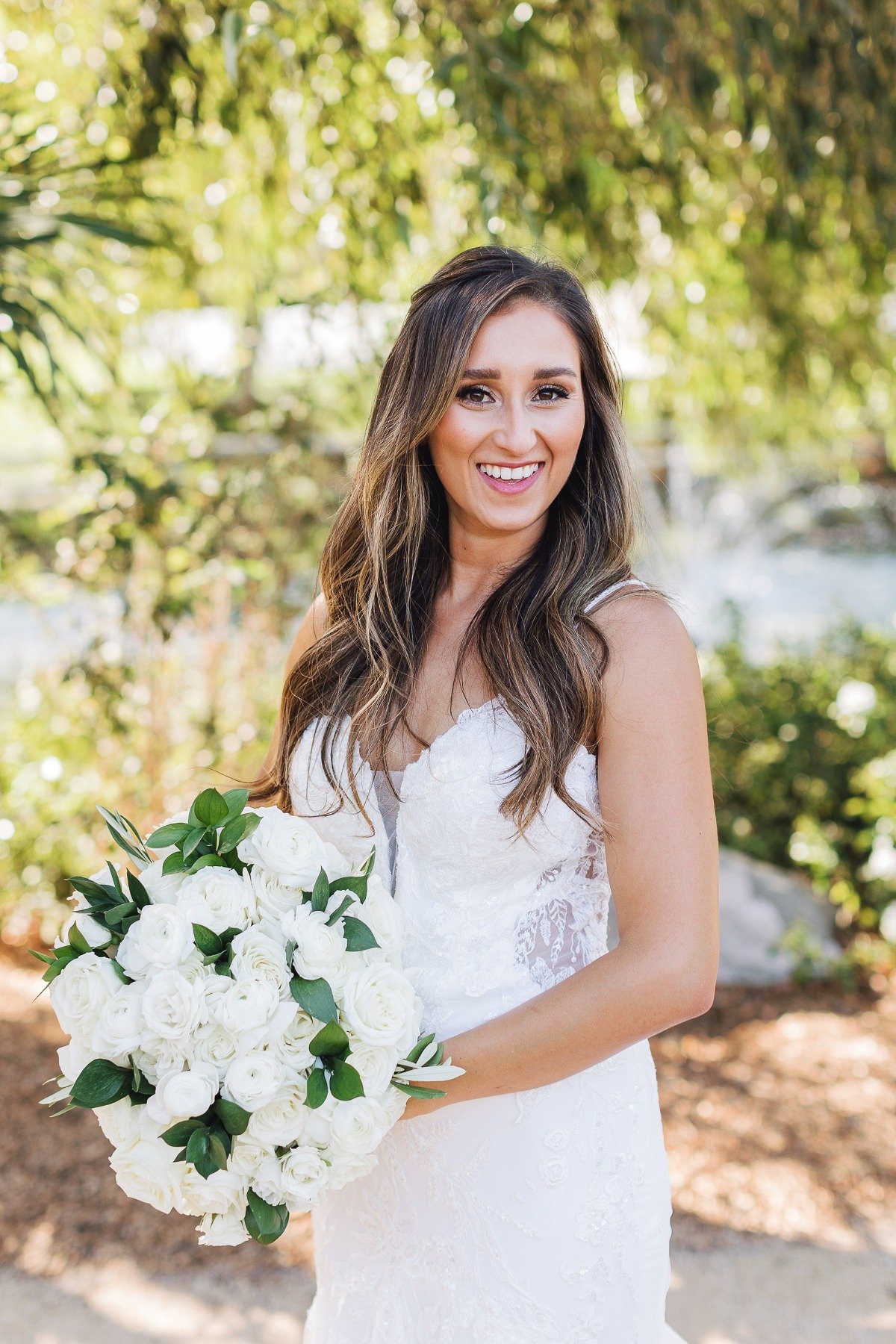 bride in lace mermaid dress with cut outs and an all white bouquet