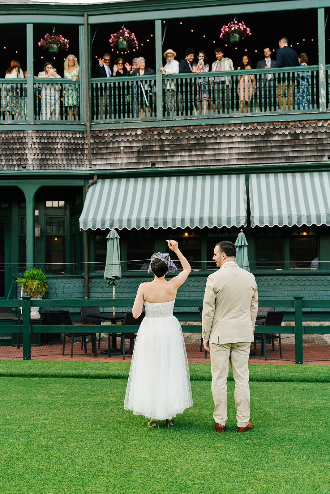 Bride and groom waving at cocktail hour