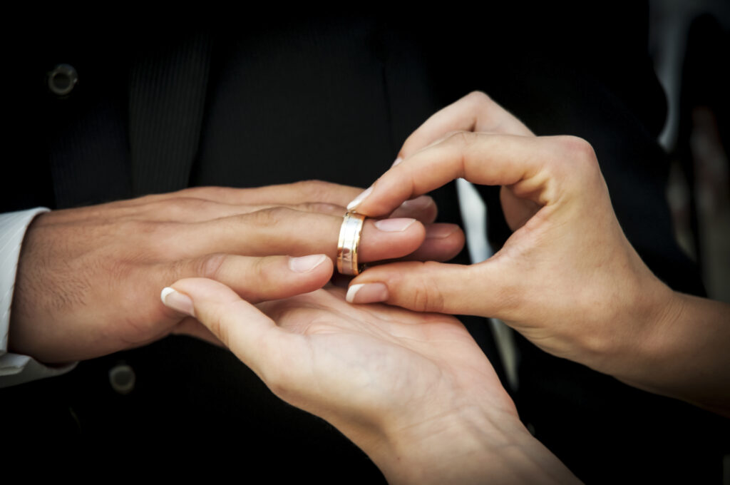 The bride is to her husband with the wedding ring on the Finger.