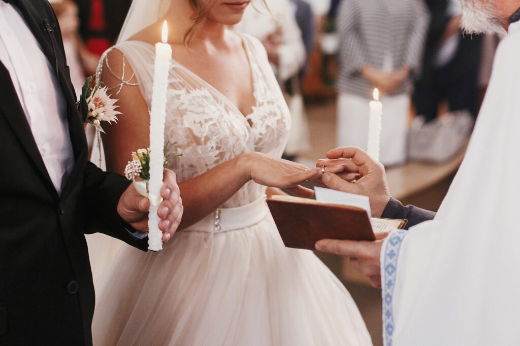 The priest hands the bride and the wedding ring for the ring exchange.