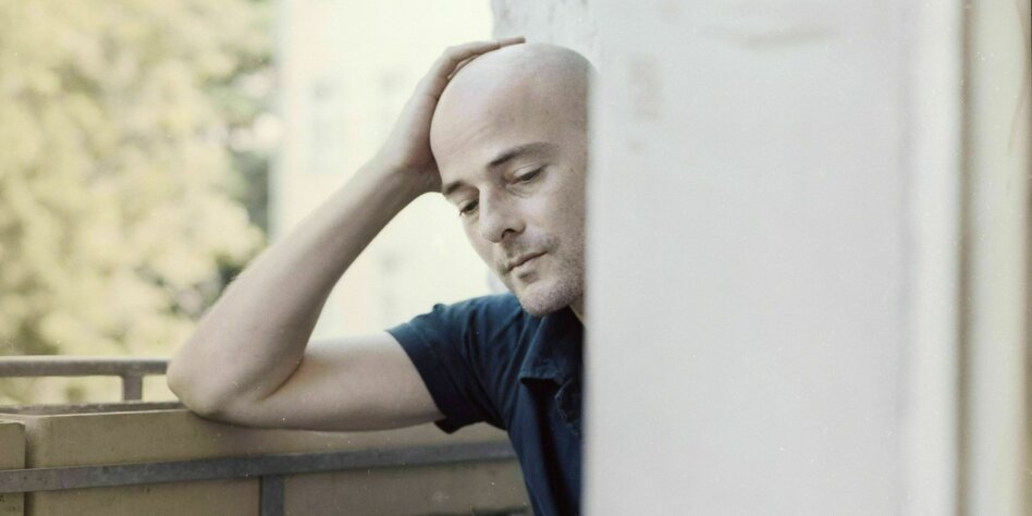 Martin Reichert sitting on his balcony,the head in the arms occupied