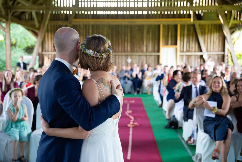 Wedding couple hugging and looking to the guests