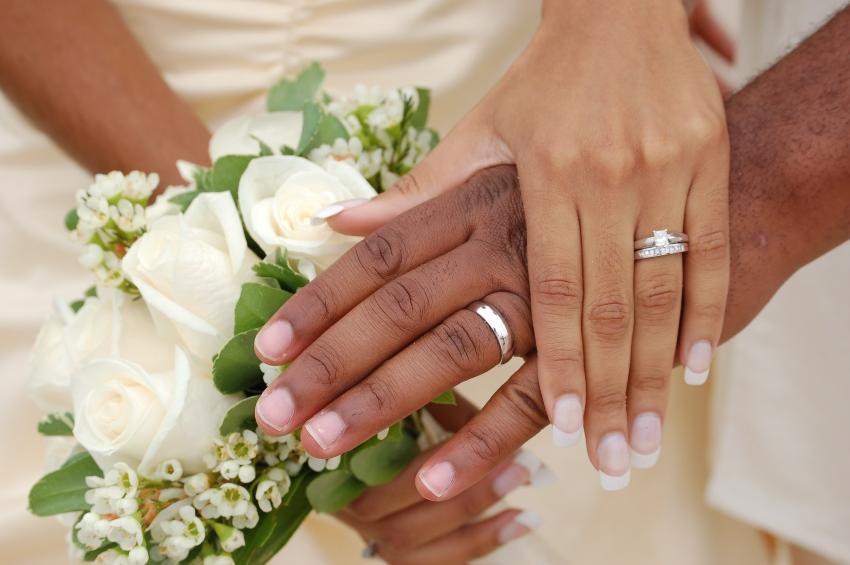 Married Couple holds hands with the rings