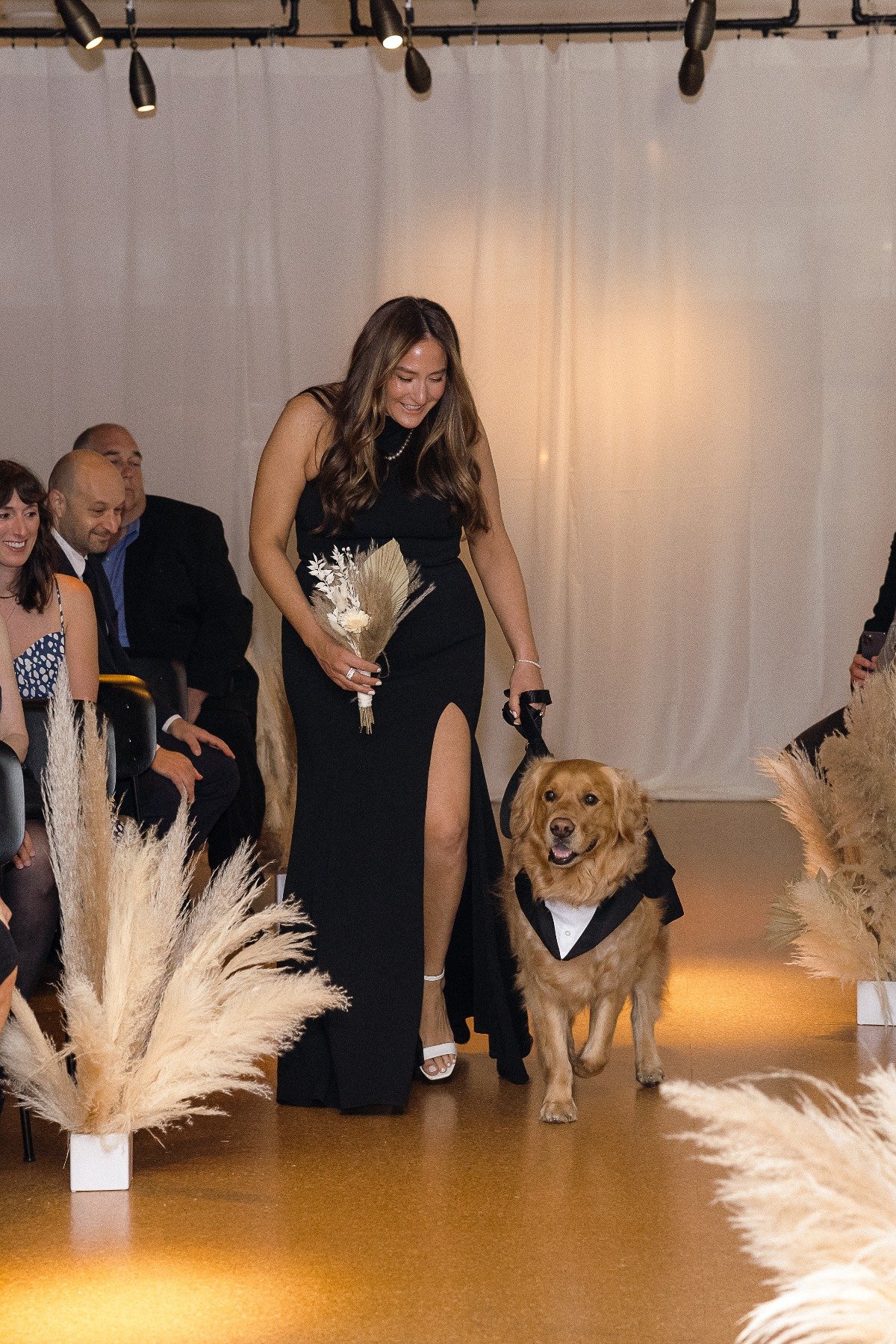 Bridesmaid walking couple's dog down aisle 