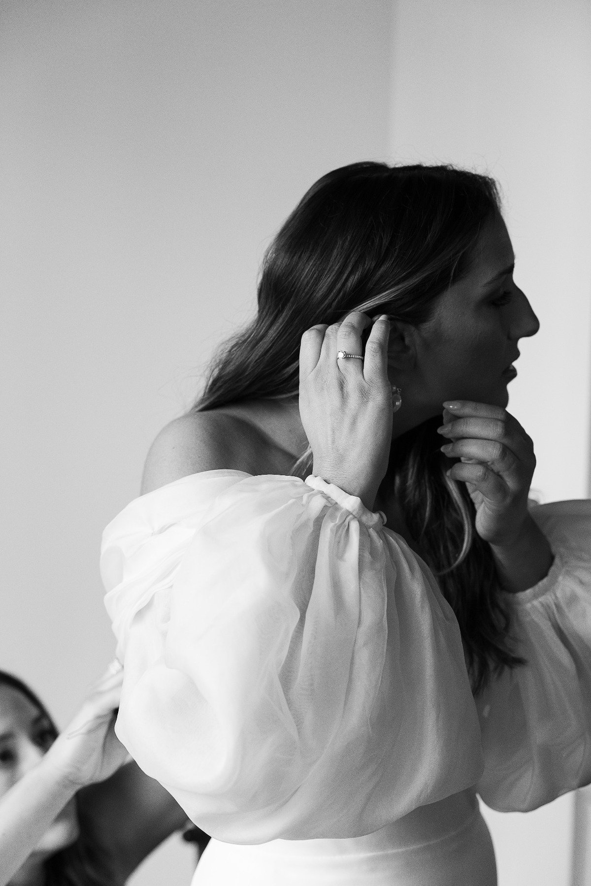 Modern bride putting on pearl earrings 