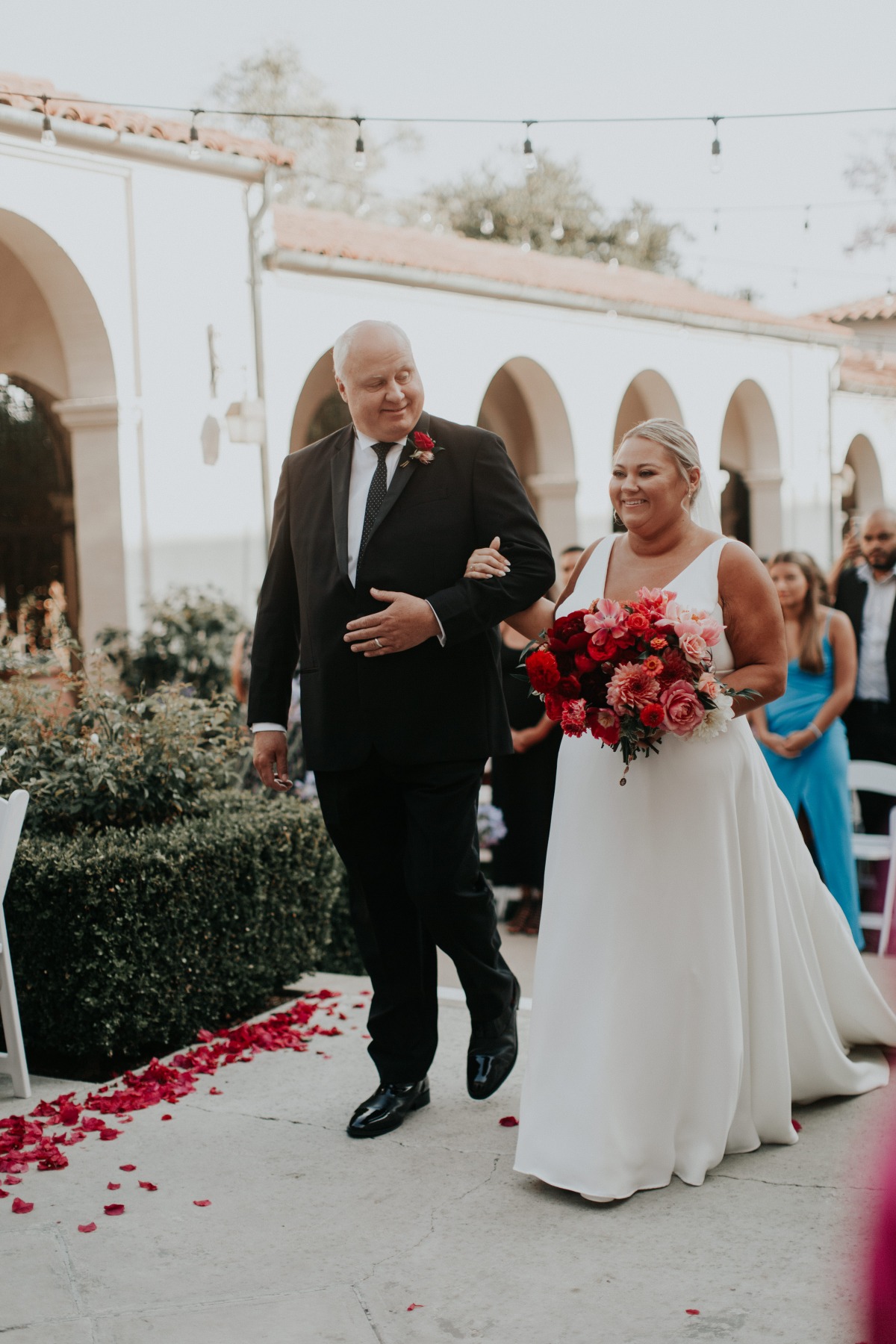 Bride walking aisle with pink bouquet