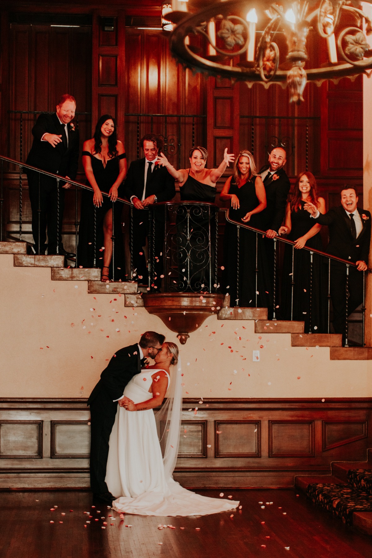 Bridal party showering newlyweds with petals 