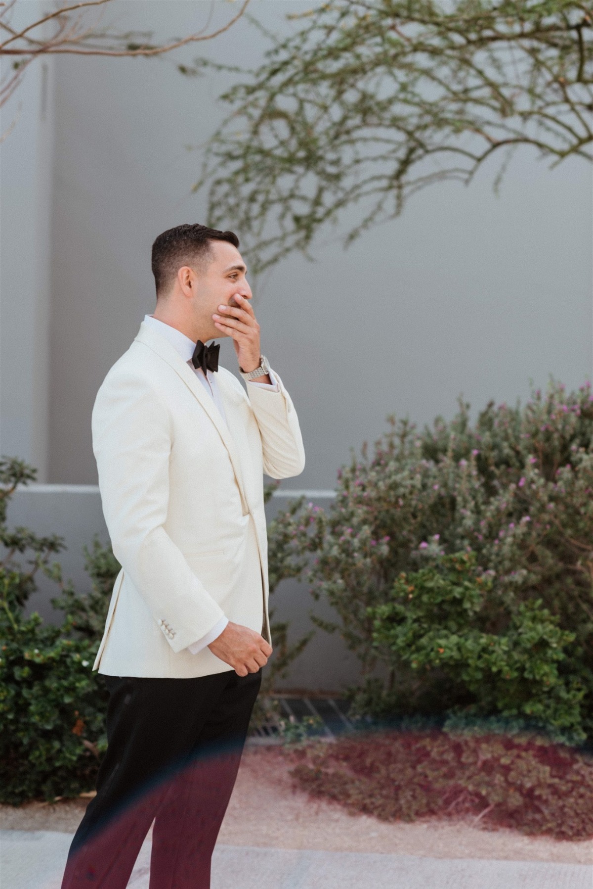 groom in white jacket for first look