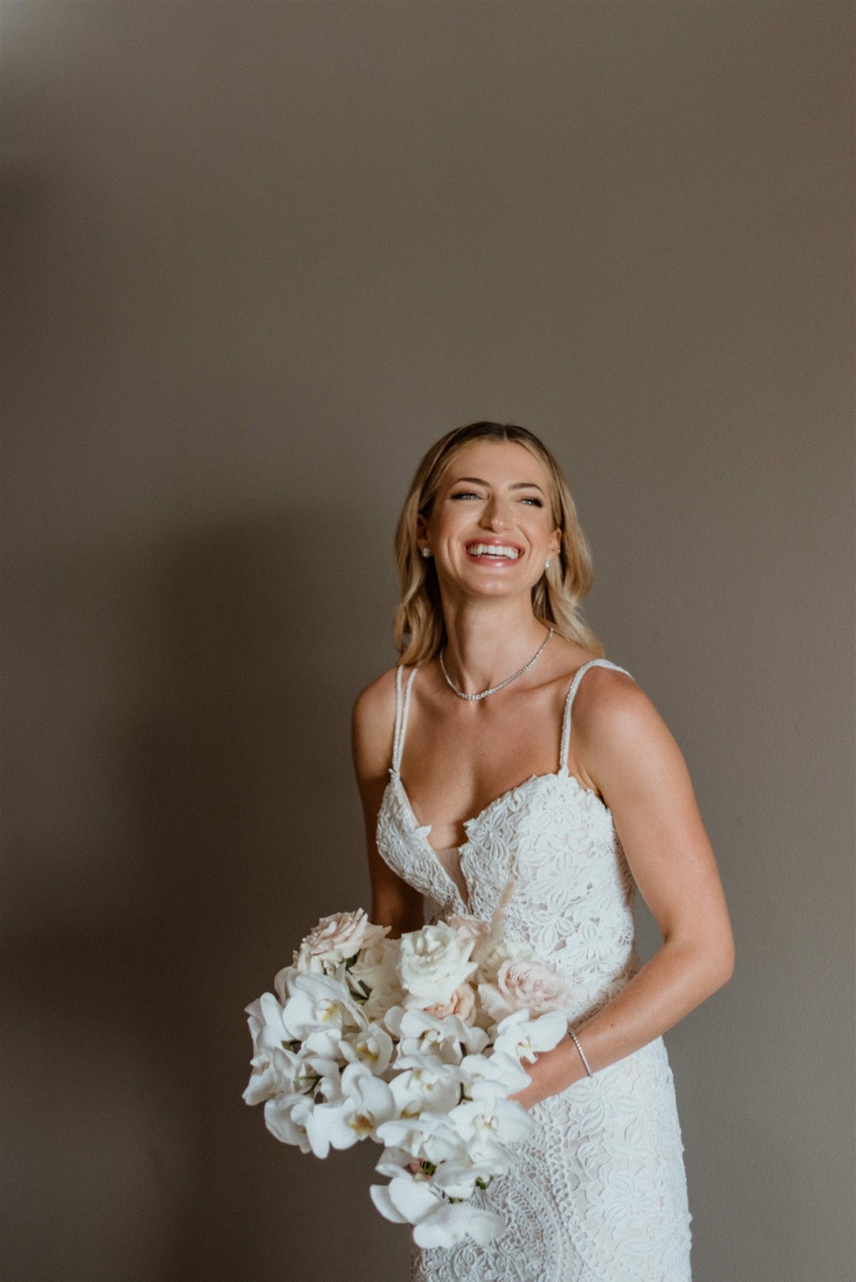 bride in lace mermaid gown with all white bouquet