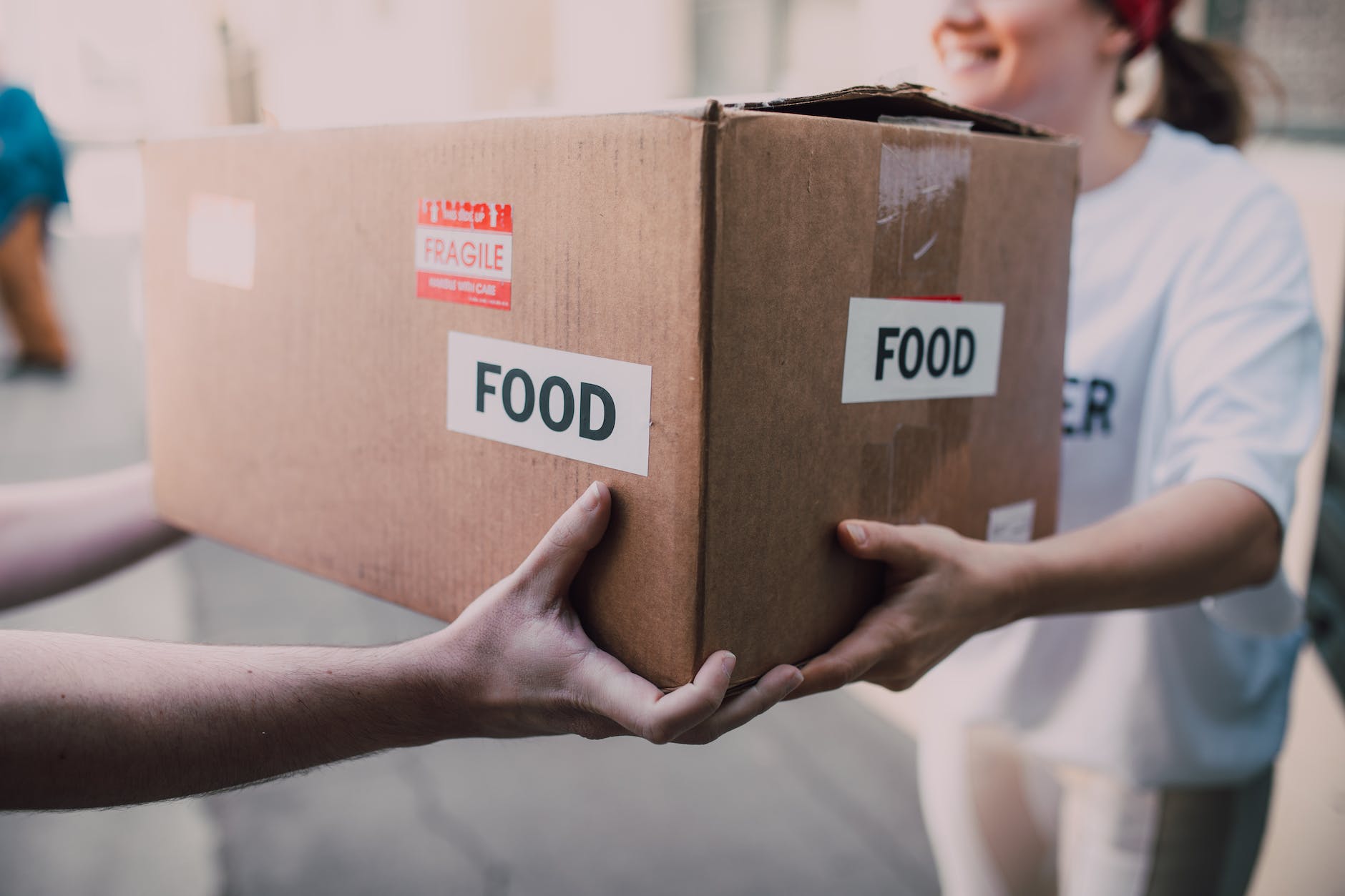 people handing over a brown box