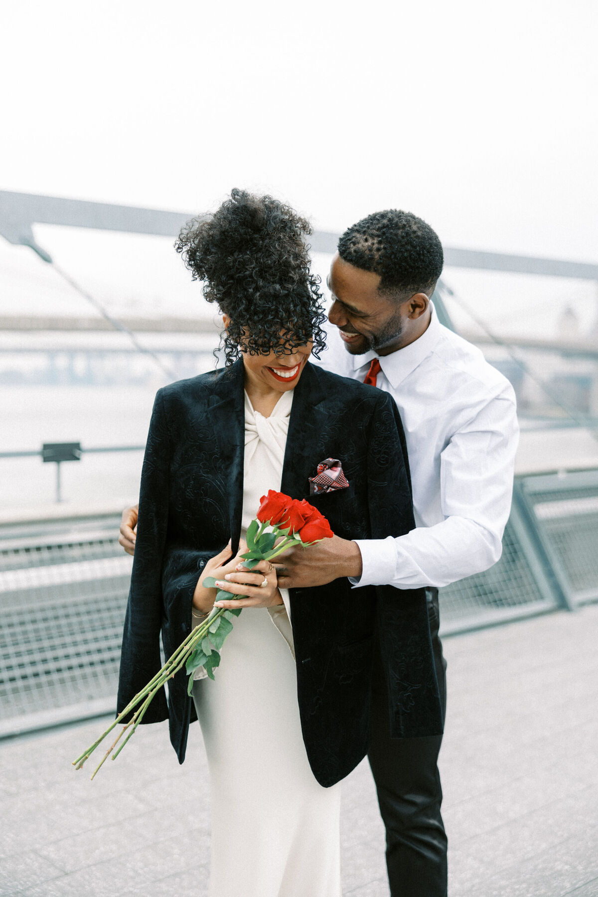 Groom putting coat around bride