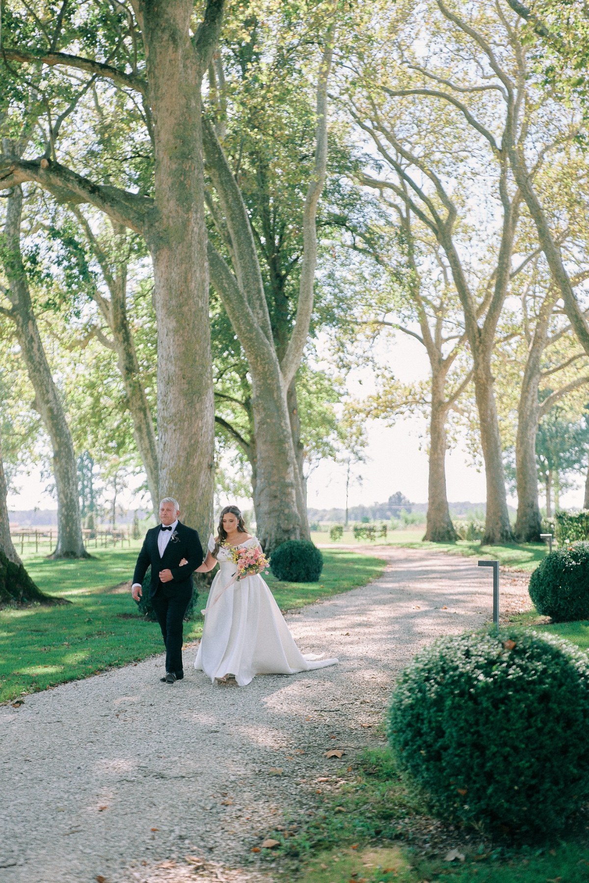 Bride walking down outdoor aisle at French wedding 