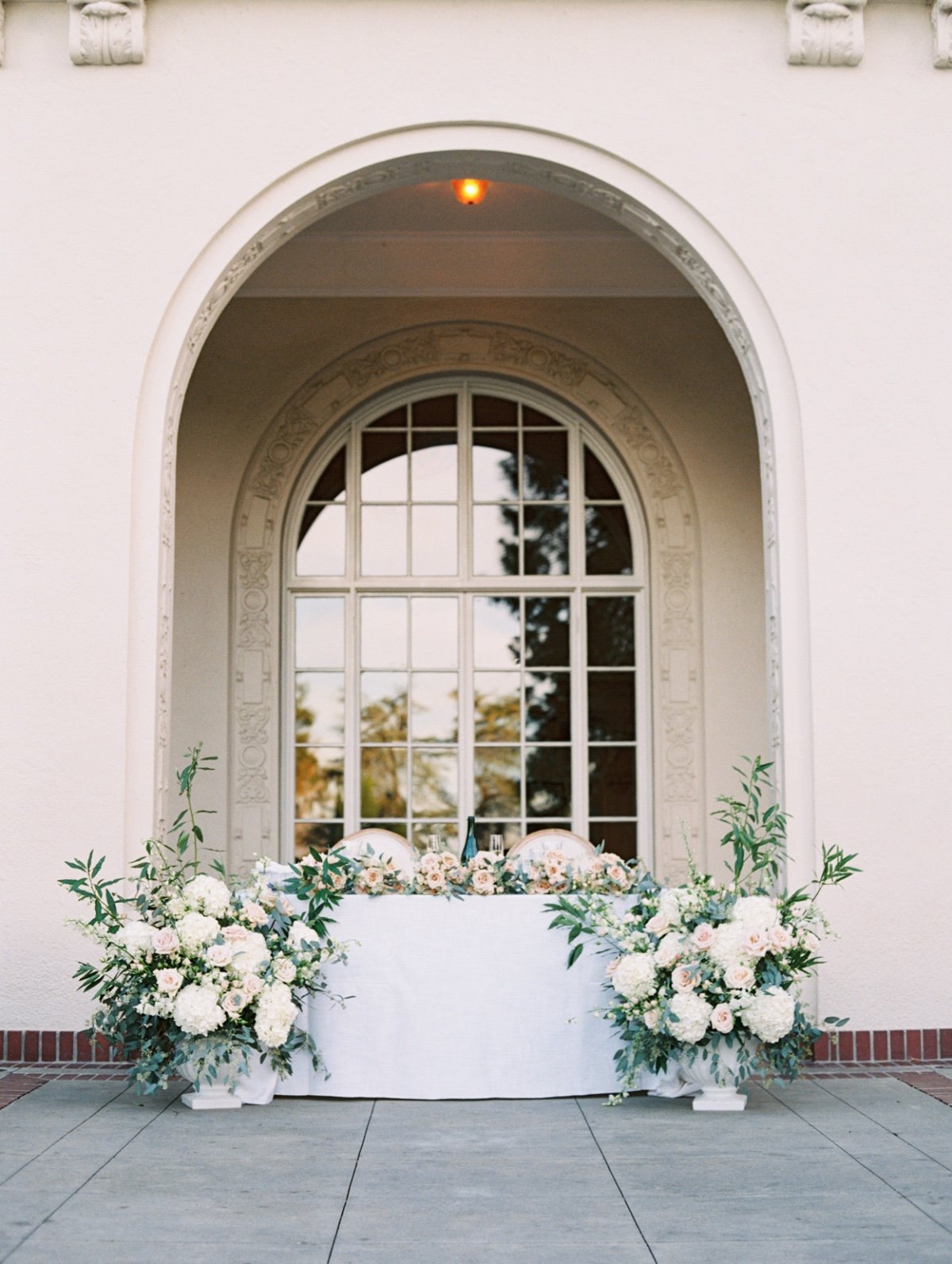 white and green sweetheart table floral arrangements