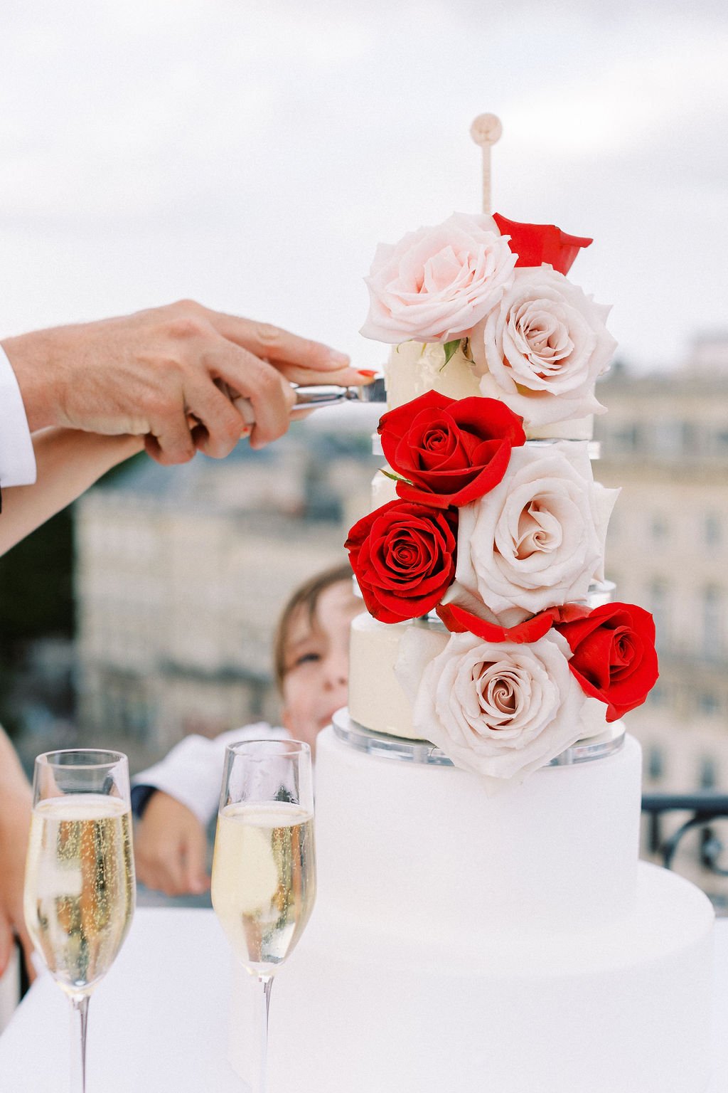 Modern floral red and pink rose topped wedding cake 