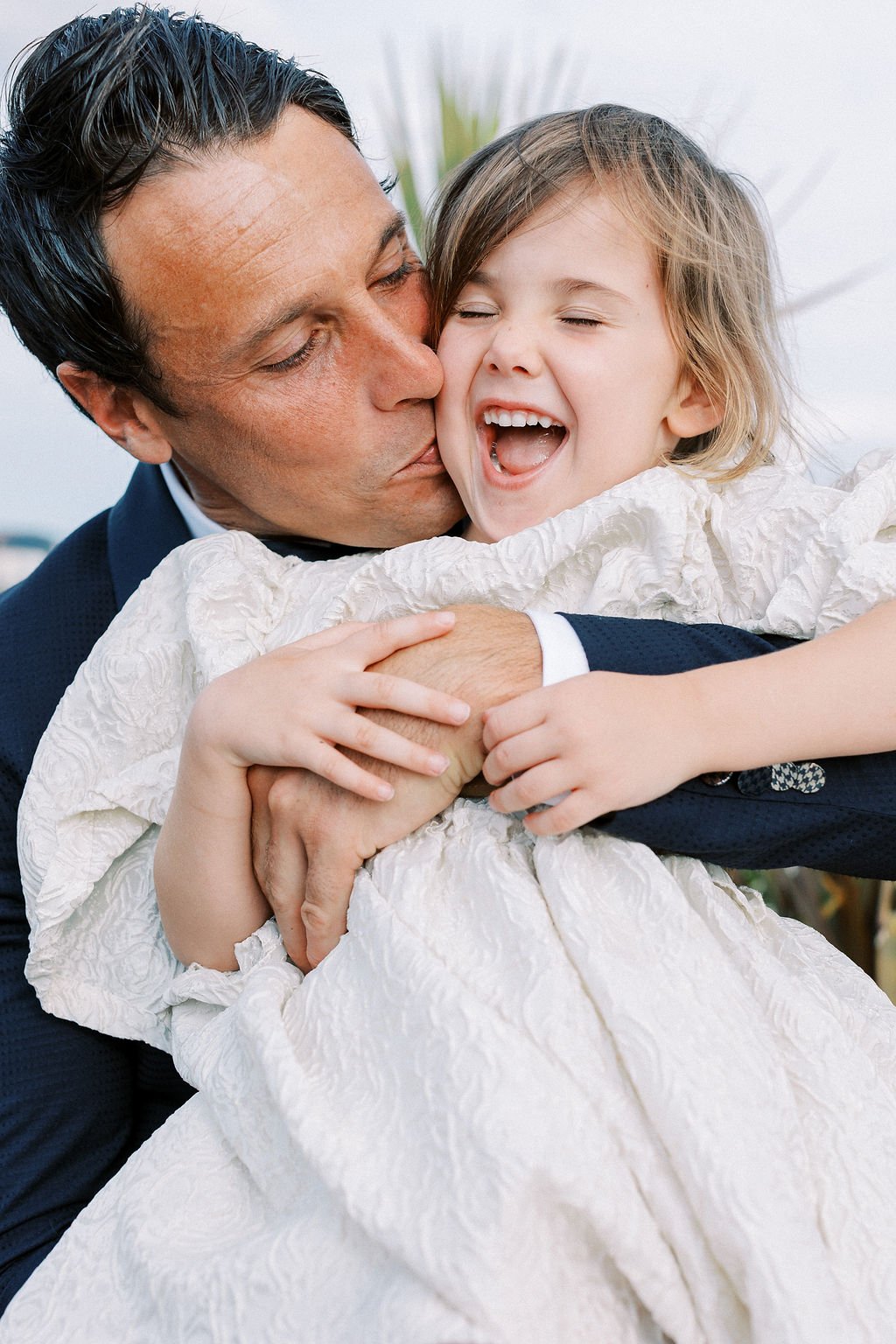 Destination groom kissing daughter at wedding elopement