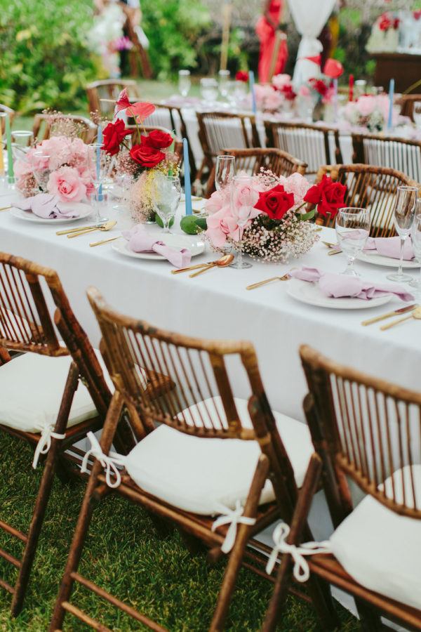 bamboo chairs with colorful florals and tall taper candles