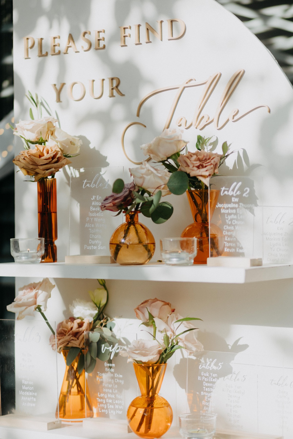 clear seating chart sign with small flower arrangements