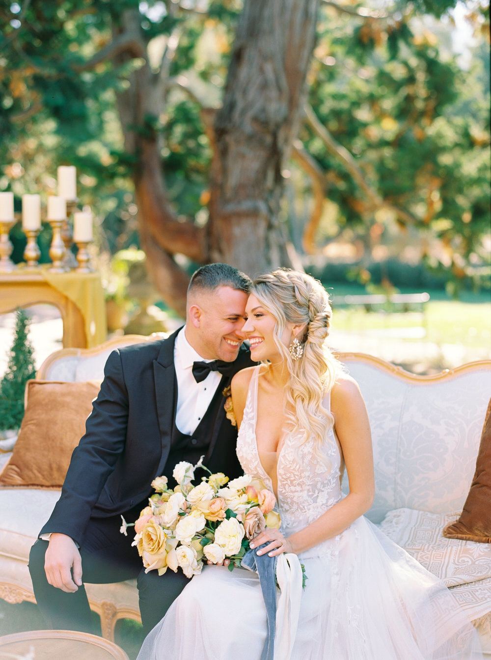 groom leans in to his bride while they both laugh together during cocktail hour