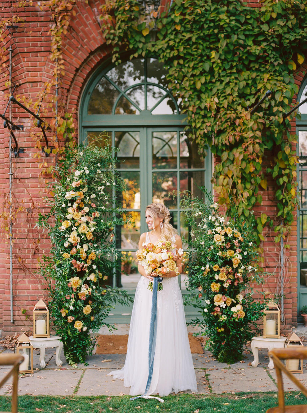 bridal portrait between the asymmetrical rose installation in pastel hues