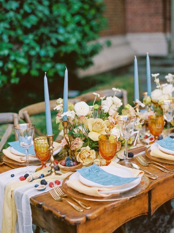 buttery yellow rose centerpieces paired with dusty blue taper candles and menu cards