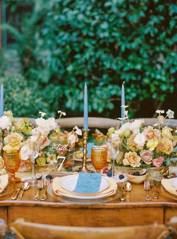 buttery yellow rose centerpieces paired with dusty blue taper candles and menu cards