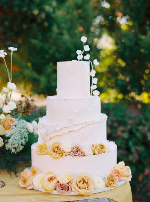 white wedding cake with deckled edging and floating florals