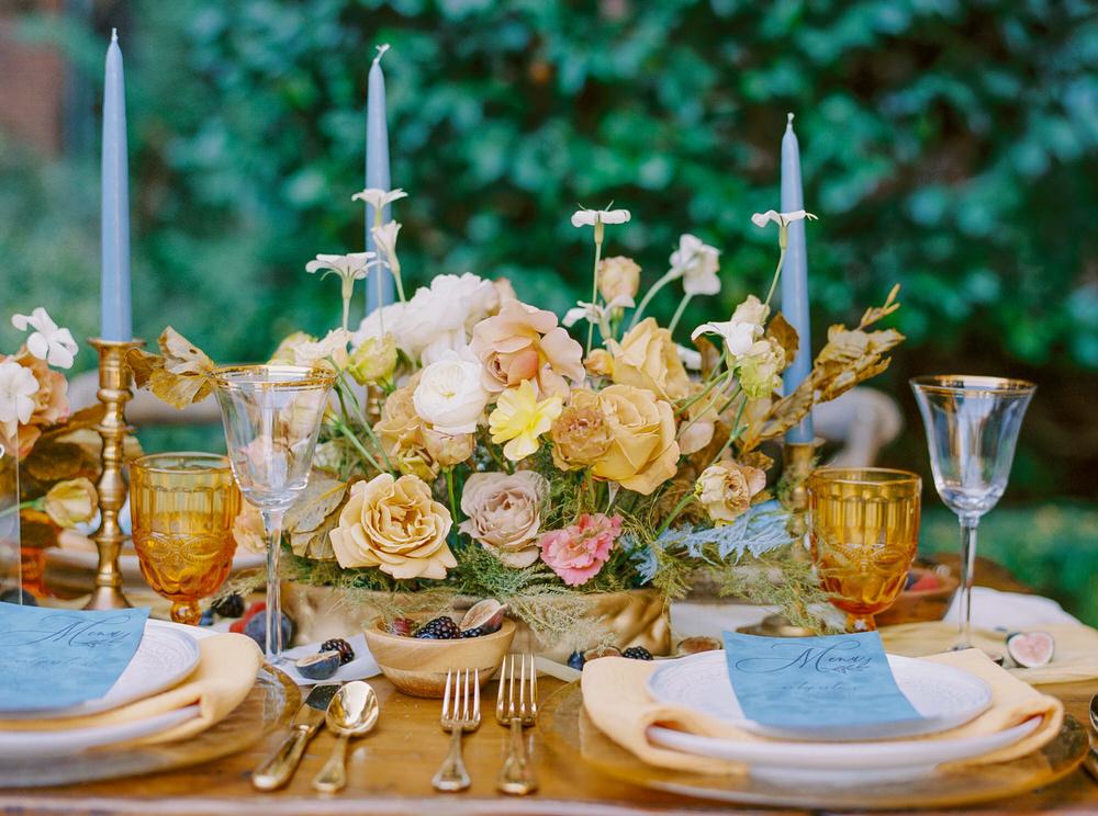 buttery yellow rose centerpieces paired with dusty blue taper candles and menu cards