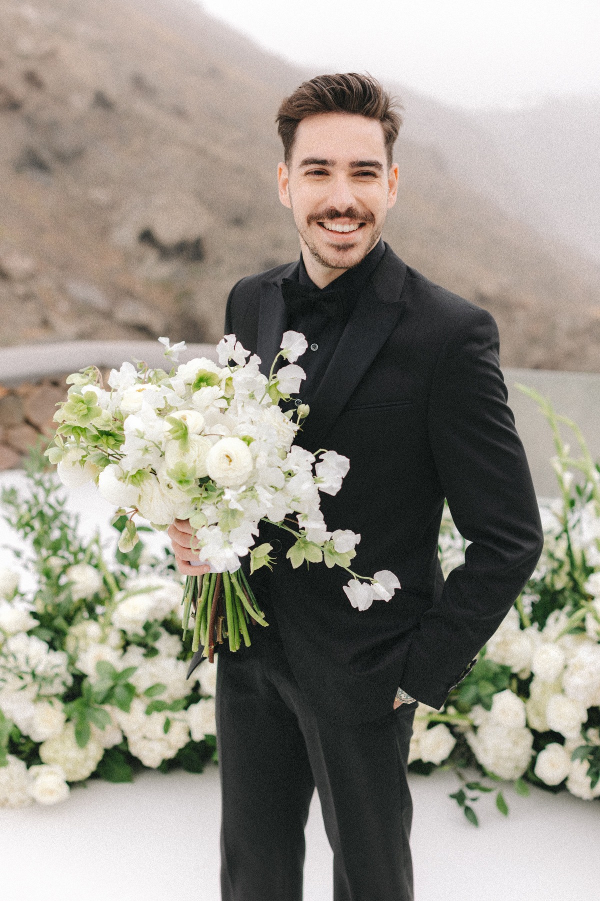 groom in black tux with black shirt and bowtie