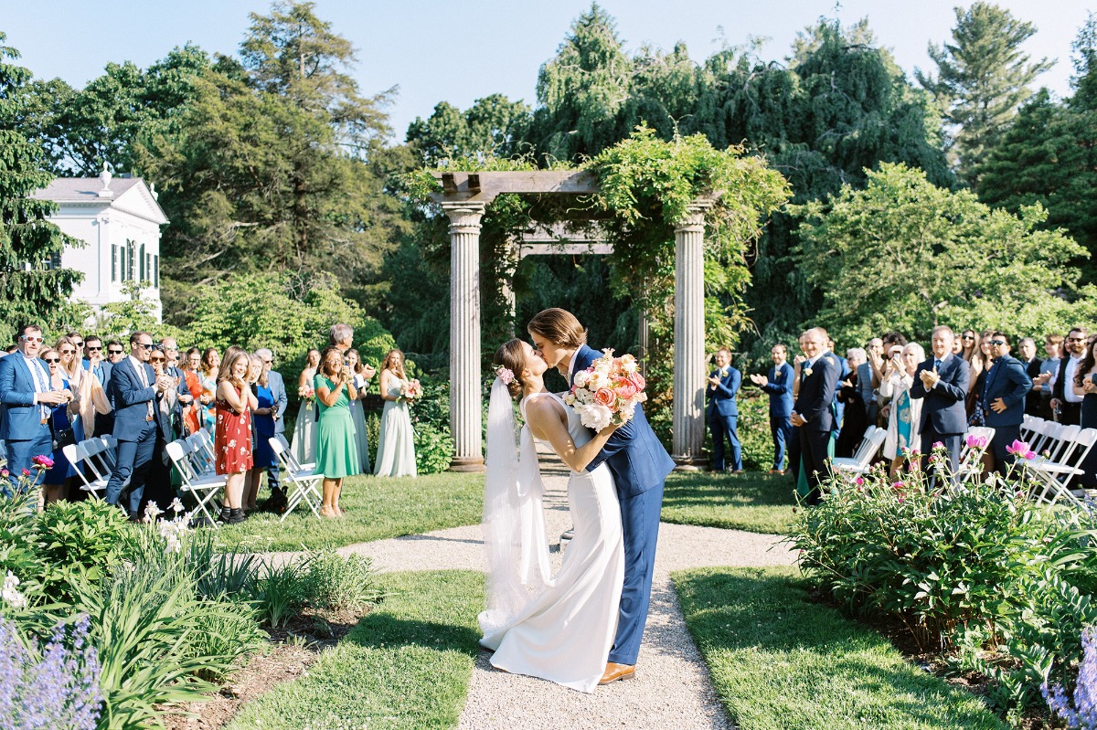 bride and groom kiss at garden wedding ceremony