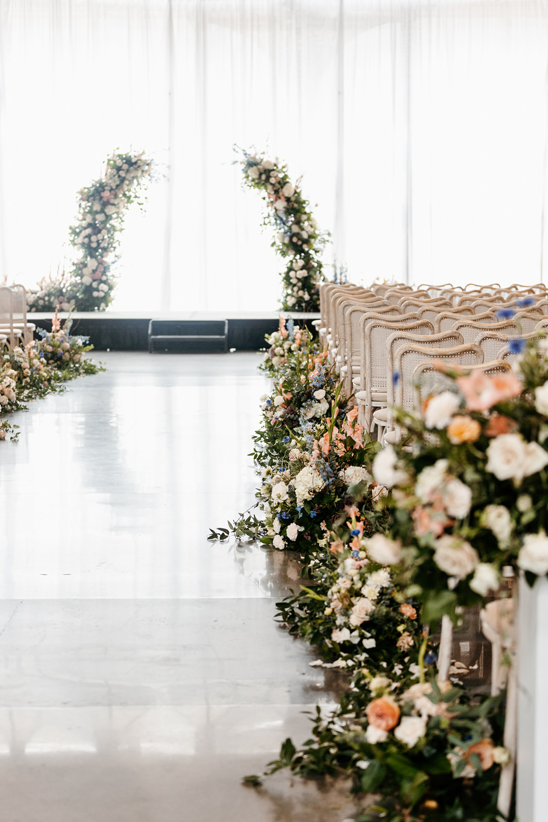 peach white and blue wedding ceremony flowers with arch