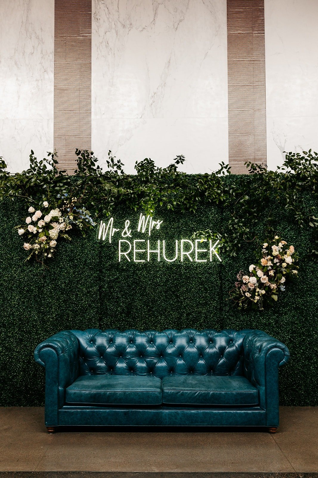 teal leather couch lounge for wedding reception with neon sign