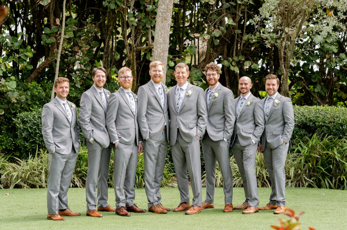 groomsmen in gray suits with blue and white floral print tie