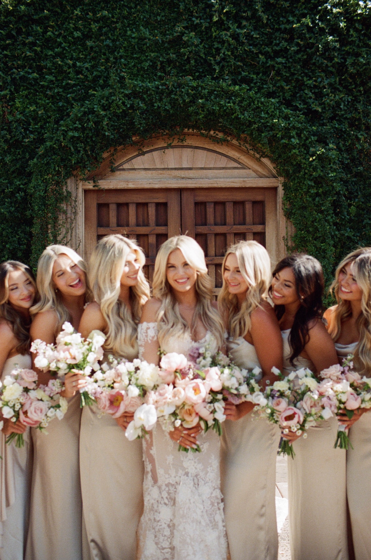 bride and bridesmaids in beige with pastel bouquets