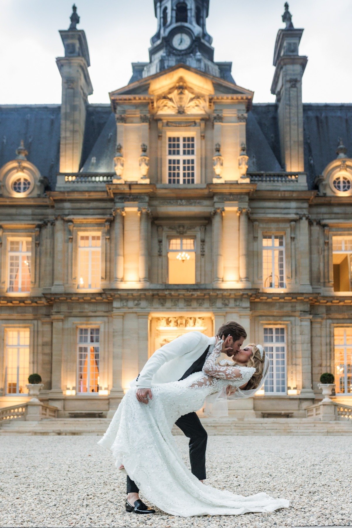 bride and groom kiss outside chateau in paris