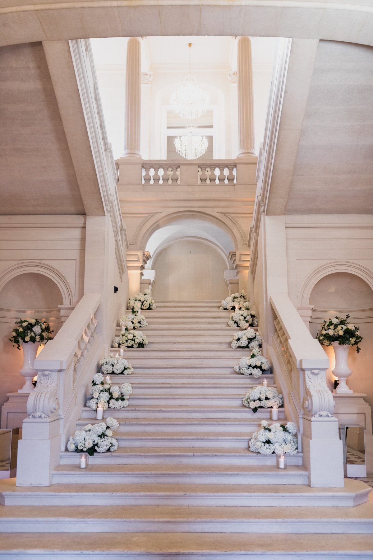 white staircase floral arrangements at wedding