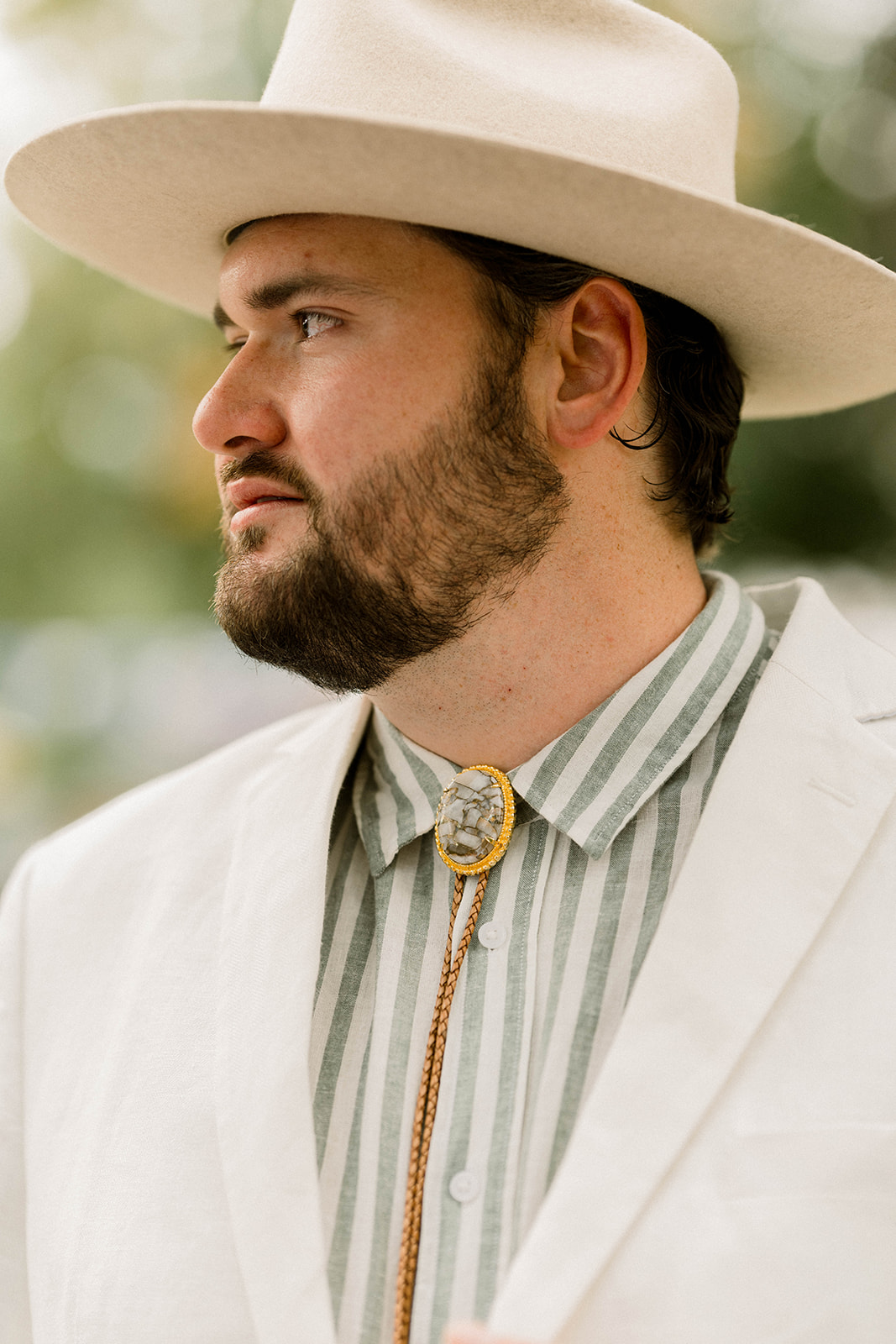 groom in linen with bolo tie and hat