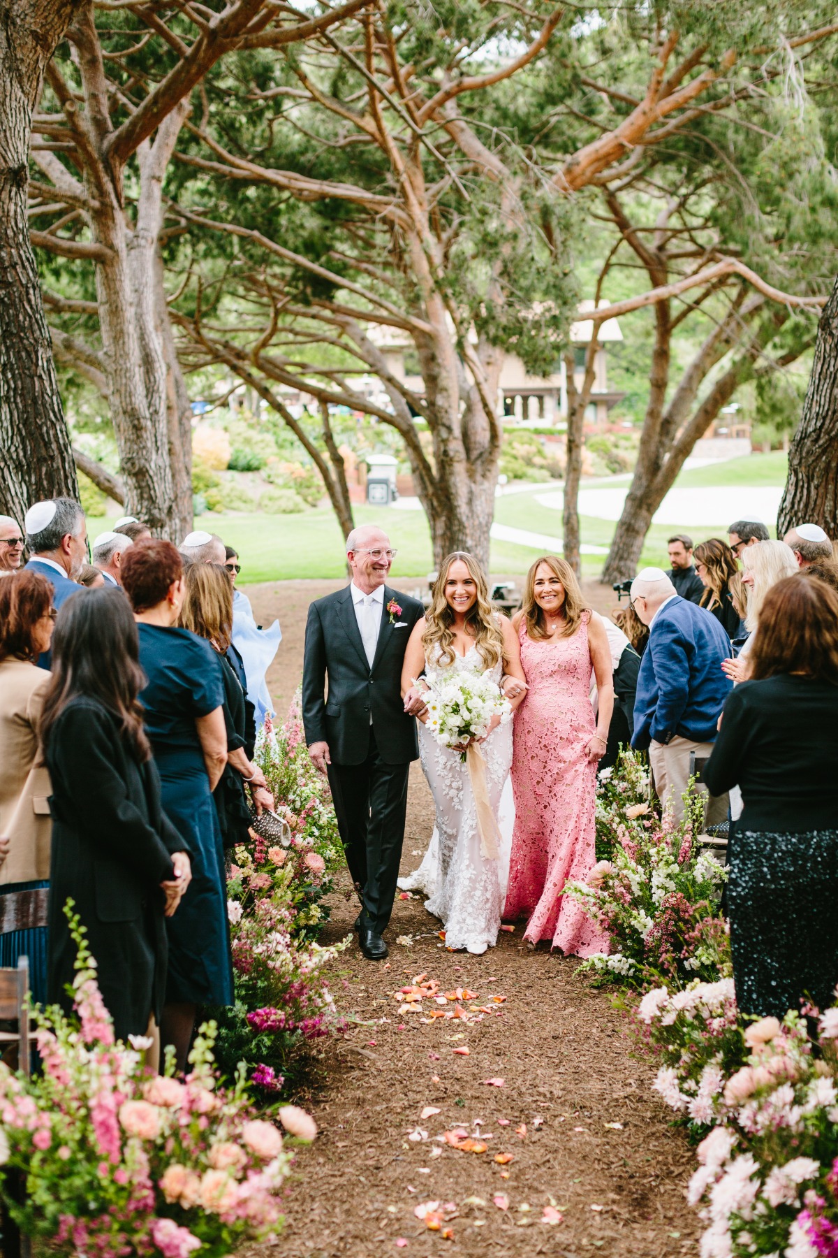 mother and father walk bride down the aisle