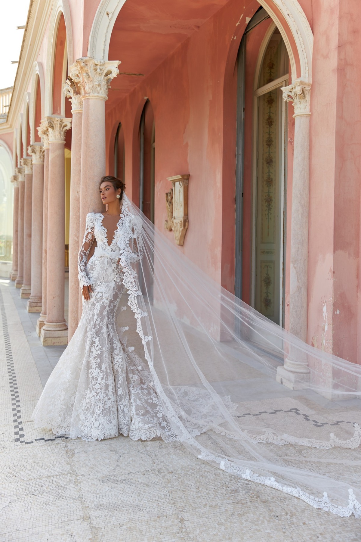 bride in long sleeve wedding dress with long veil