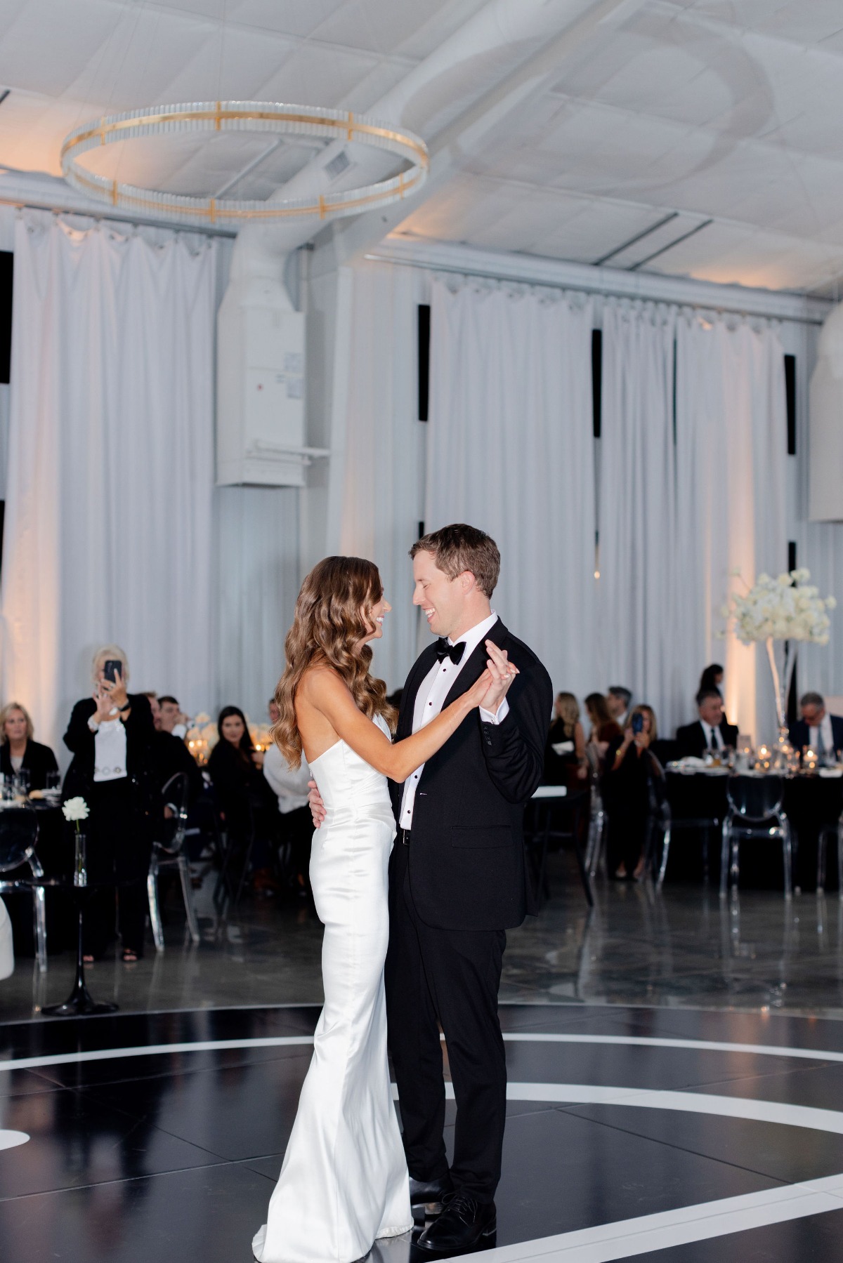 bride and groom dancing on black and white monogrammed dance floor