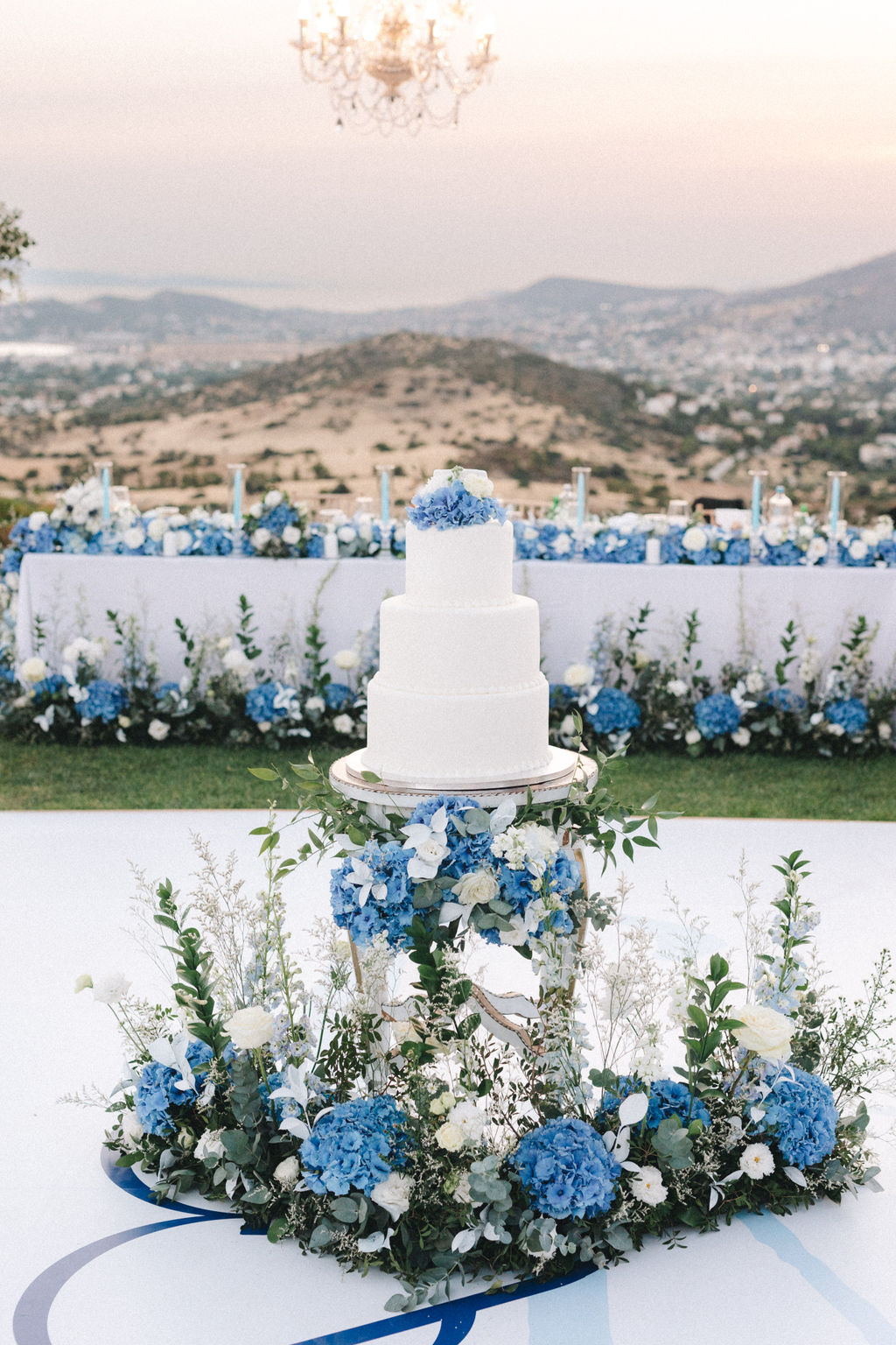 blue and white wedding cake display with live flowers