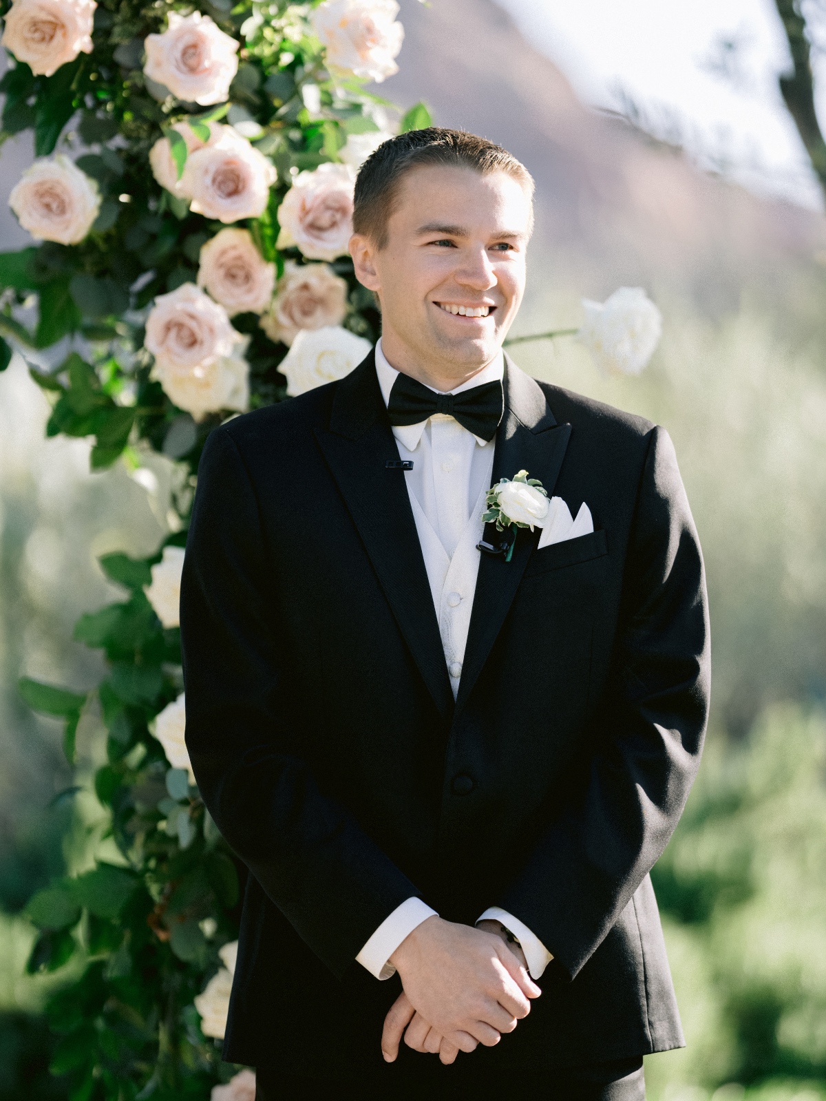 groom in black tux with ivory vest