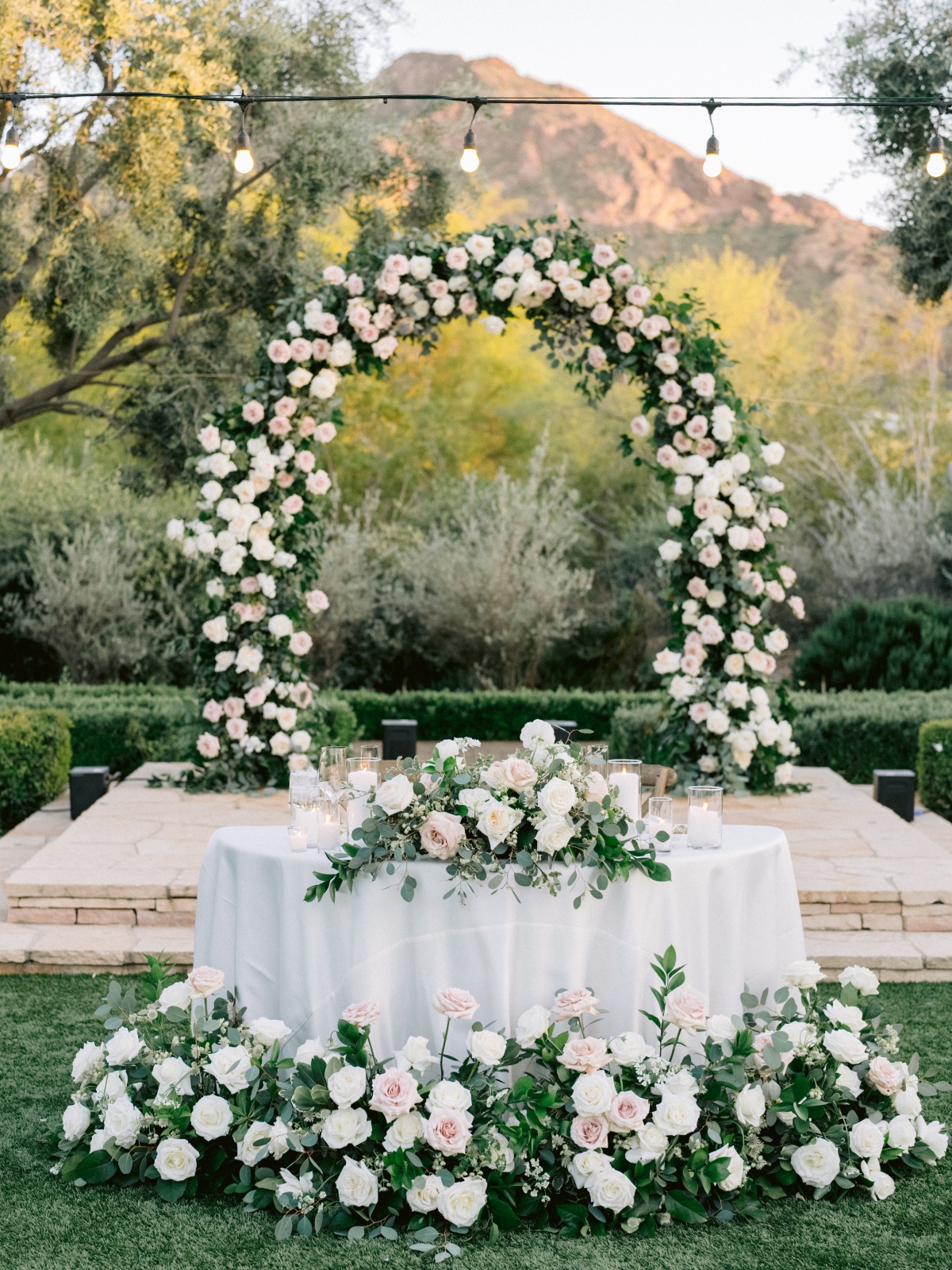 sweetheart table with blush and ivory floral arch