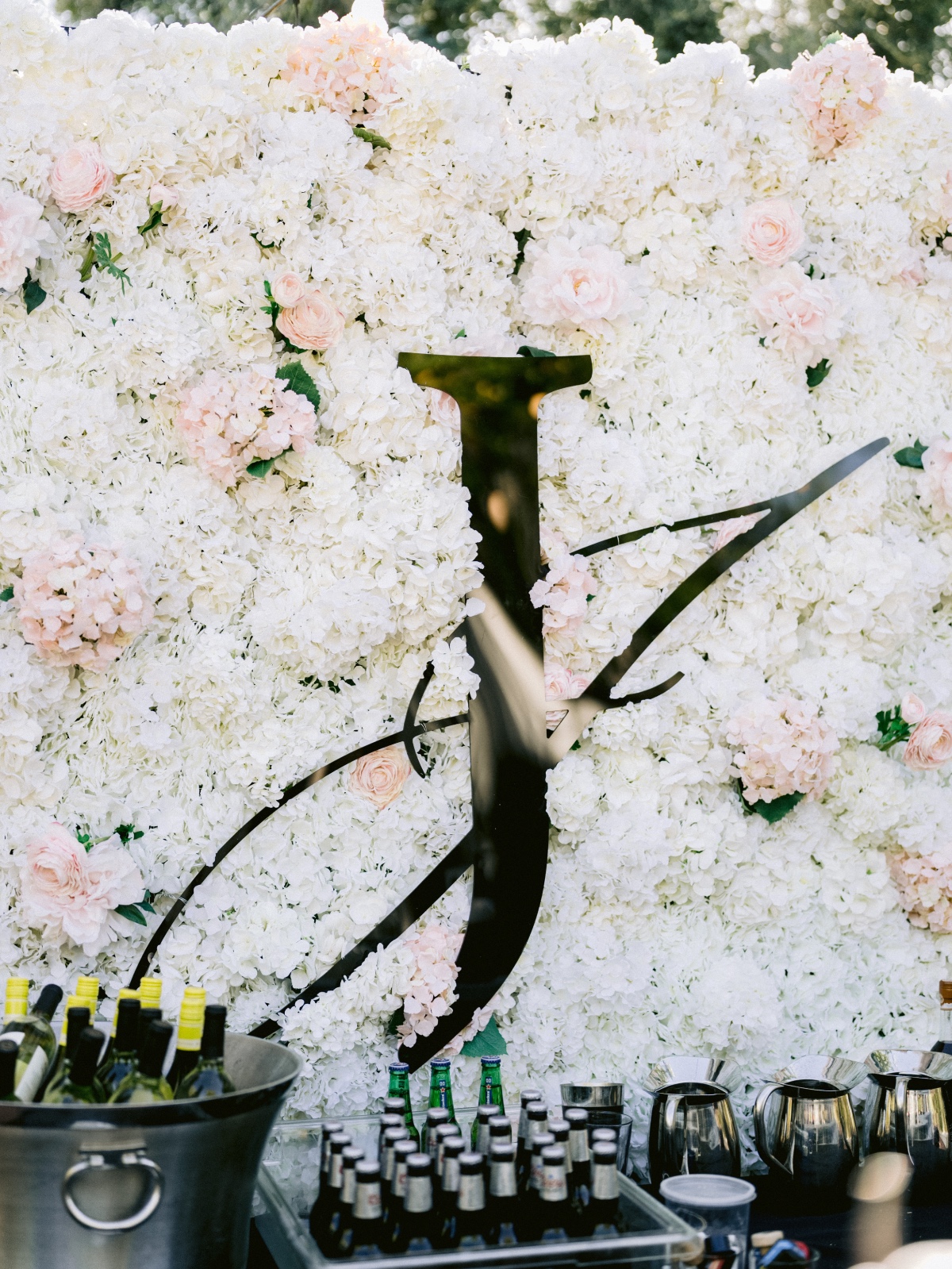 floral wall backdrop for bar at wedding with monogram